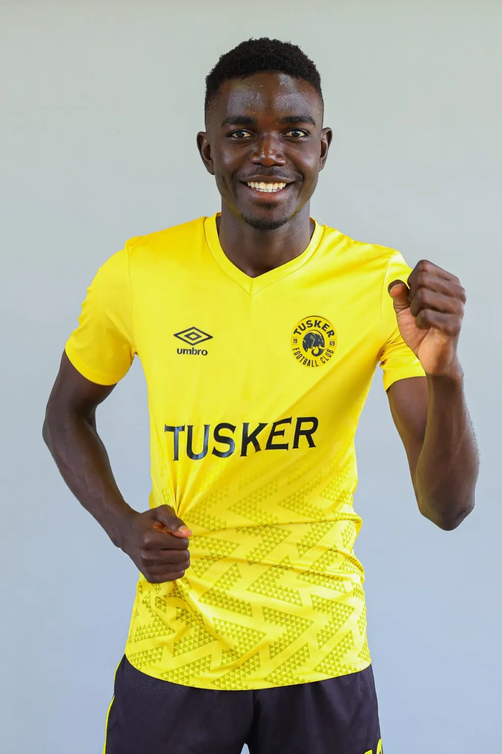 Stephen Ochieng Omondi in a yellow Tusker Football Club shirt, photographed against a plain backdrop.